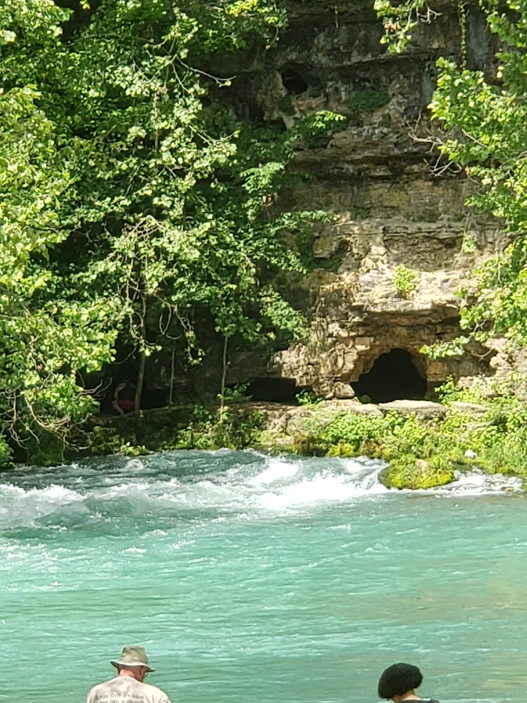 Clear blue Ozarks spring flowing beside a rocky bluff